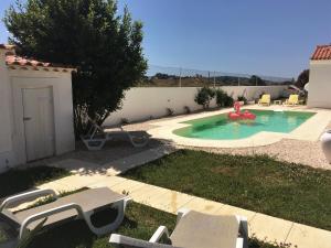 un patio trasero con una piscina con un flotador rojo. en Portela Guesthouse, en Cercal