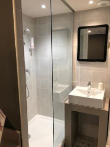 y baño con lavabo y ducha con espejo. en Hôtel Saint Roch Montpellier Centre, en Montpellier