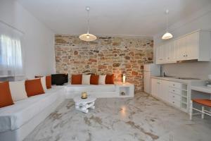a living room with a white couch and a brick wall at Tinos Peristerionas in Tinos