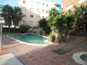 a swimming pool in front of a building at Apartamentos Palas Salou in Salou