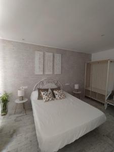 a bedroom with a large white bed with pillows at Apartamento Laura in Peñíscola