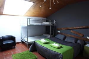 sypialnia z łóżkiem piętrowym i krzesłem w obiekcie Albergue "ARANTZAKO ATERPEA" w mieście Arantza