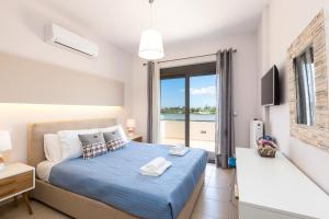 a bedroom with a bed with a view of the ocean at Peris Villa in Kato Daratso +60 photos