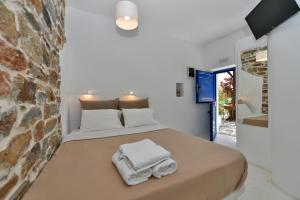 1 dormitorio con 1 cama con toallas en Tinos Peristerionas, en Tinos