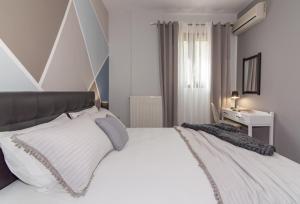 a bedroom with a large white bed with white pillows at Valentine's Modern Apartment in Zakynthos Town