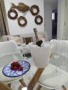 un tavolo con una bottiglia di champagne e un piatto di fragole di Apartamento Laura a Peñíscola
