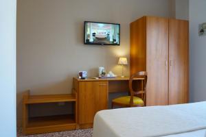 una camera d'albergo con scrivania e TV a parete di Villa Susy Relais a Sant'Agnello