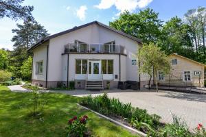 a large white house with a balcony at Poilsis prie Dineikos parko in Druskininkai
