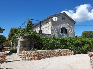 ein Steingebäude mit einer Uhr darüber in der Unterkunft Villa Diny with Pool in Pinezici