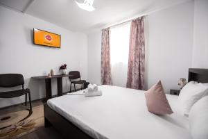 a bedroom with a white bed and a table and chairs at Eden House in Costinesti