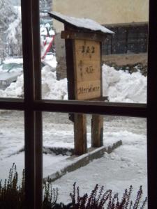 una finestra con vista su una casetta per uccelli nella neve di Alle Meridiane a Monclassico