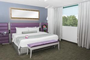 1 dormitorio con 1 cama grande y paredes moradas en Crowne Plaza Toluca - Lancaster, an IHG Hotel en Toluca