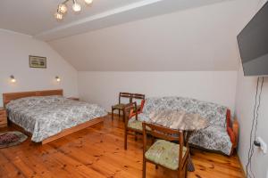 1 dormitorio con cama, mesa y sofá en Poilsis prie Dineikos parko, en Druskininkai