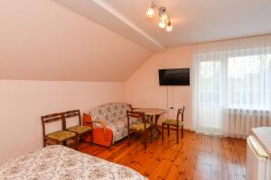 Zimmer mit einem Tisch und Stühlen sowie einem TV in der Unterkunft Poilsis prie Dineikos parko in Druskininkai