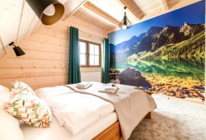ein Schlafzimmer mit einem großen Wandbild eines Sees in der Unterkunft Apartamenty Augustynówka in Brzegi