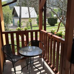 patio ze stołem i krzesłami na ganku w obiekcie Apartament Na Rozdrożu w Cisnej