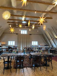 a large room with tables and chairs and chandeliers at Café Mandeltårtan B&B VillaFloraViola in Ronneby