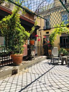 un patio con due sedie e un albero in un edificio di Dimora san giovanni maggiore a Napoli