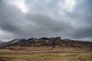 a mountain in the middle of a field with a sky at Dalahyttur in Hlíð í Hörðudal