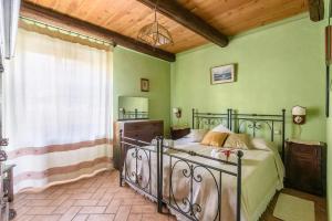 a bedroom with a bed and green walls at Borgo Sanguineto in Tuoro sul Trasimeno