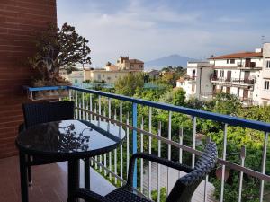 un tavolo e sedie su un balcone con vista di Villa Susy Relais a Sant'Agnello