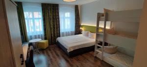 a small bedroom with a bunk bed and a desk at Hotel Goldene Traube in Günzburg