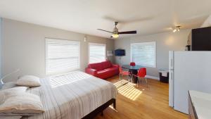 1 dormitorio con 1 cama y 1 silla roja en Sun Beach Inn, en Hollywood