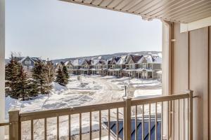 a balcony with a view of snow covered houses at Executive Town Home-Mountain View-Historic Snowbridge Village, Walking Distance to the Resort in Collingwood