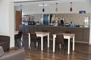 a kitchen with two tables and chairs and a counter at Microtel Inn & Suites by Wyndham Fond Du Lac in Fond du Lac