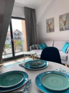 una mesa con tres placas azules encima. en Apartament Marco, en Krynica Morska