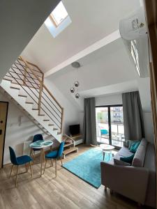 un soggiorno con scala e sedie blu di Apartament Marco a Krynica Morska