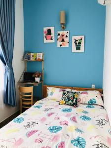um quarto com uma cama e uma parede azul em HD House Homestay Vũng Tàu em Vung Tau