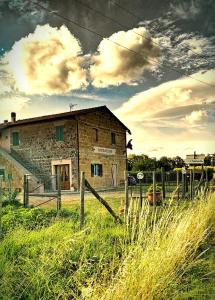 un ancien bâtiment en pierre dans un champ d'herbe dans l'établissement Castelvecchio B&B, à Sorano