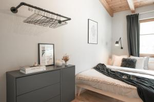 a bedroom with a bed with a dresser and a window at Home@Moos in Pfunds