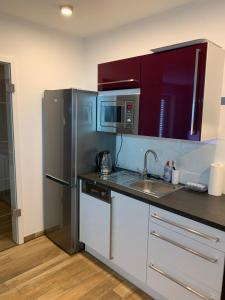 a kitchen with a stainless steel refrigerator and a sink at 2-Zimmer-Wohnung bei Nürnberg mit S-Bahn-Anschluss in Postbauer-Heng