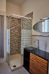 uma casa de banho com uma cabina de duche em vidro e um lavatório. em Villa Esmeralda em Rimini