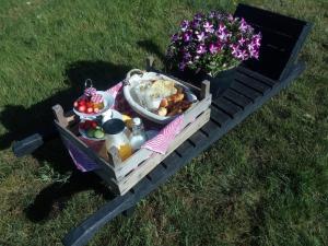 Ein Picknicktisch mit Essen und Blumen auf dem Rasen in der Unterkunft B&B De Flecht - De Ljip in Nijega + 24 Fotos