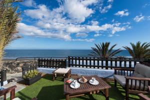 a patio with a view of the ocean at A Dream On The Beach Sun Club in Playa del Aguila