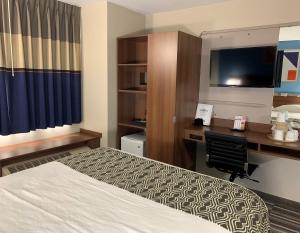 a hotel room with a bed and a desk at Microtel Inn & Suites by Wyndham Fond Du Lac in Fond du Lac