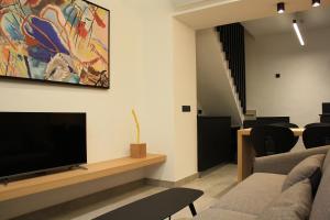 uma sala de estar com uma televisão de ecrã plano na parede em LA ALMACERÍA DE ANTEQUERA em Antequera