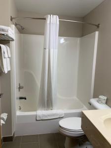 a bathroom with a white tub and a toilet and a sink at Microtel Inn & Suites by Wyndham Fond Du Lac in Fond du Lac +12 photos