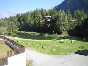 uitzicht op een park met een rivier en een huis bij Le Prarion 2 in Les Houches