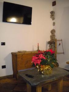 Una habitación con una mesa con un jarrón de flores. en Alle Meridiane, en Monclassico