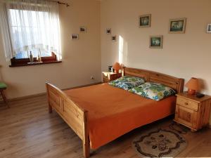 a bedroom with a wooden bed and a night stand at Apartamenty i pokoje u Beaty in Augustów