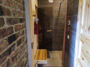 a bathroom with a walk in shower next to a brick wall at Ele kodumajutus in Pärnu