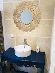 ein Bad mit einem Waschbecken und einem Wandspiegel in der Unterkunft Residence Cabiscol in Beaucaire