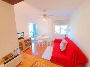 uma sala de estar com um sofá vermelho e uma mesa em APARTAMENTO PALS BEACH-3 em Pals