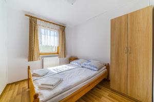 1 dormitorio con 1 cama y armario de madera en Litoral Domki Lubkowo, en Krokowa