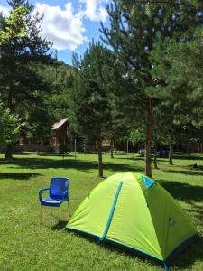 una tienda verde y una silla azul en un campo en Agara Pansiyon, en Taşkıran