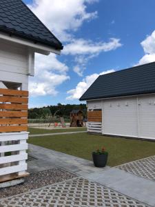 a house with a playground in the background at Merinn in Rogowo